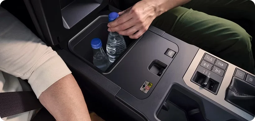 Open center-console cool box compartment inside the Land Cruiser