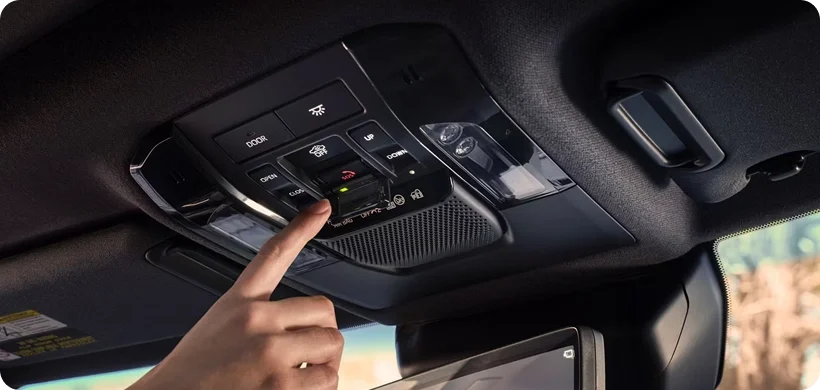 Driver pressing the Safety Connect SOS button on the Land Cruiser overhead console