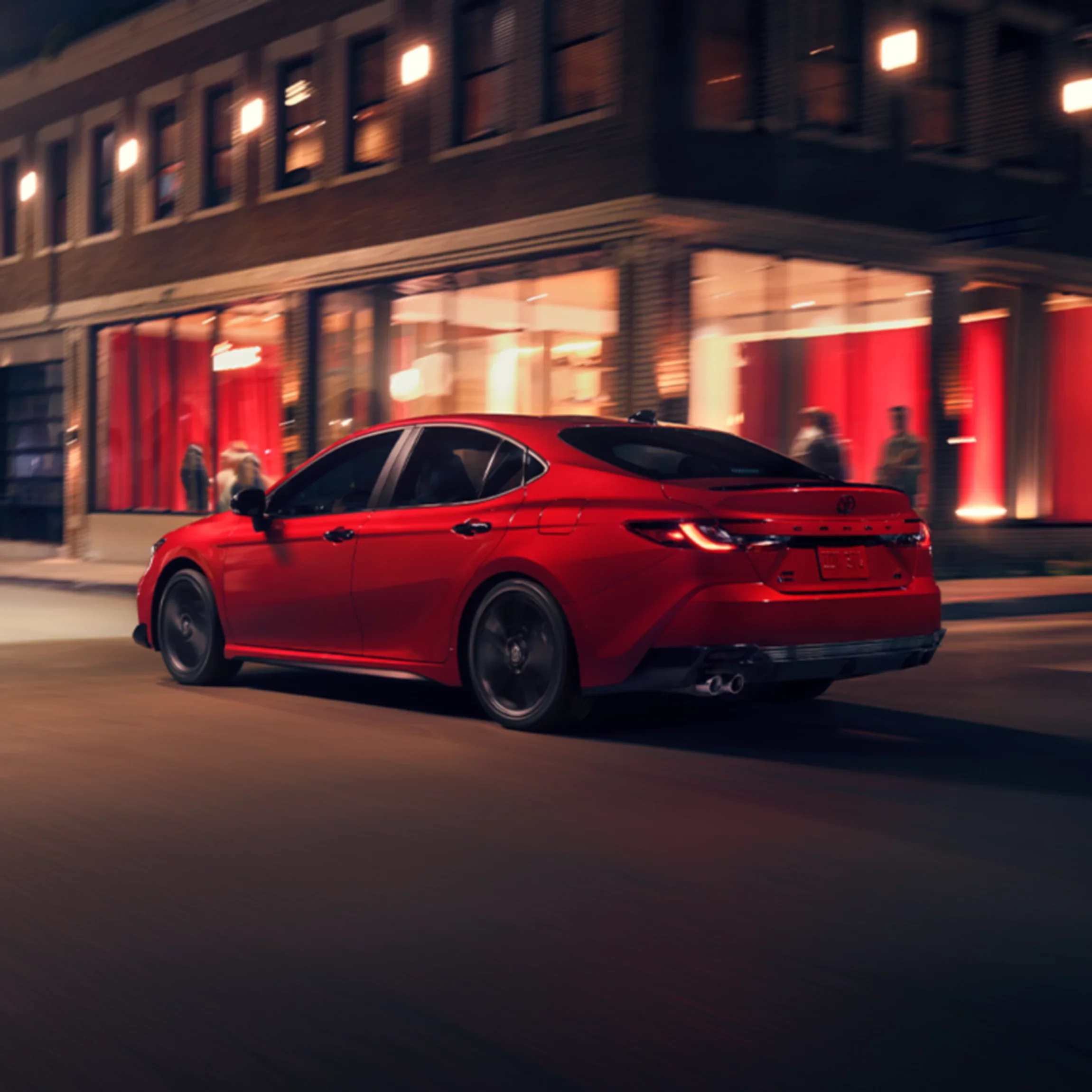 Red 2026 Toyota Camry on a city street at night — trims we compare at Dalton Toyota National City