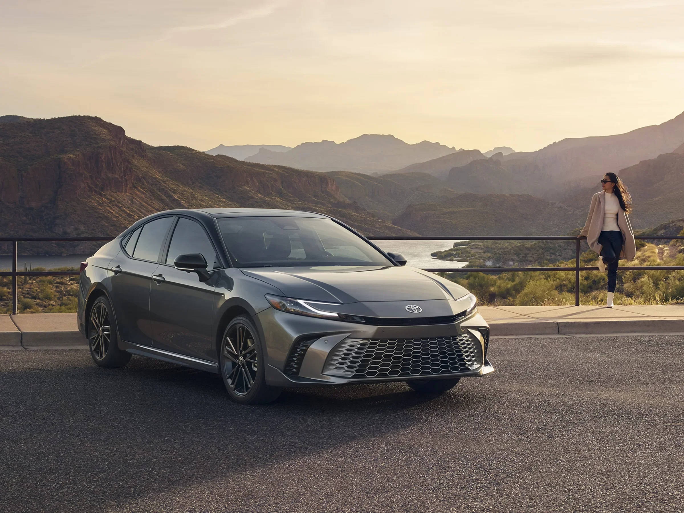 A gray Toyota Camry parked at a mountain overlook at sunset