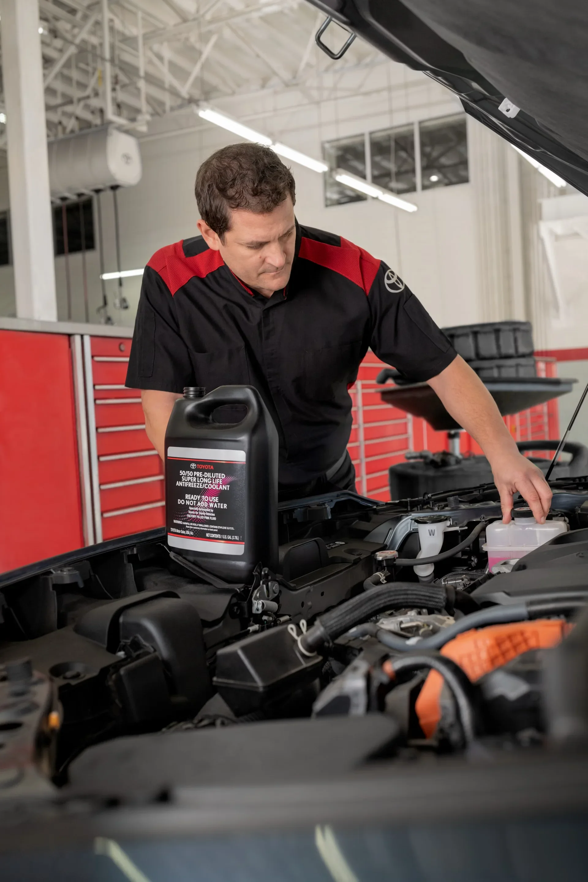 A Toyota technician checking the engine during an oil change
