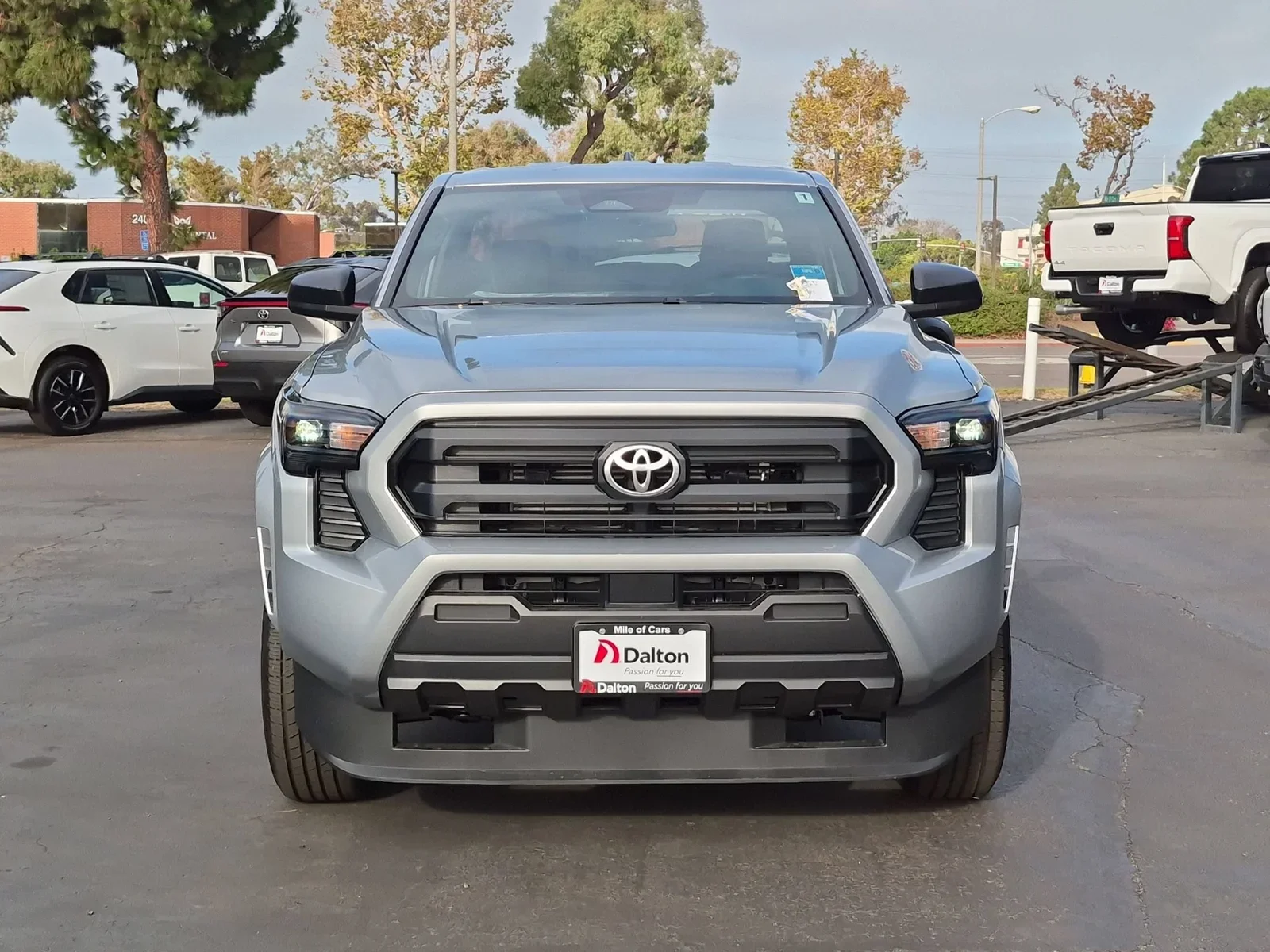 A silver 2026 Toyota Tacoma seen from the front on the lot at Dalton Toyota National City