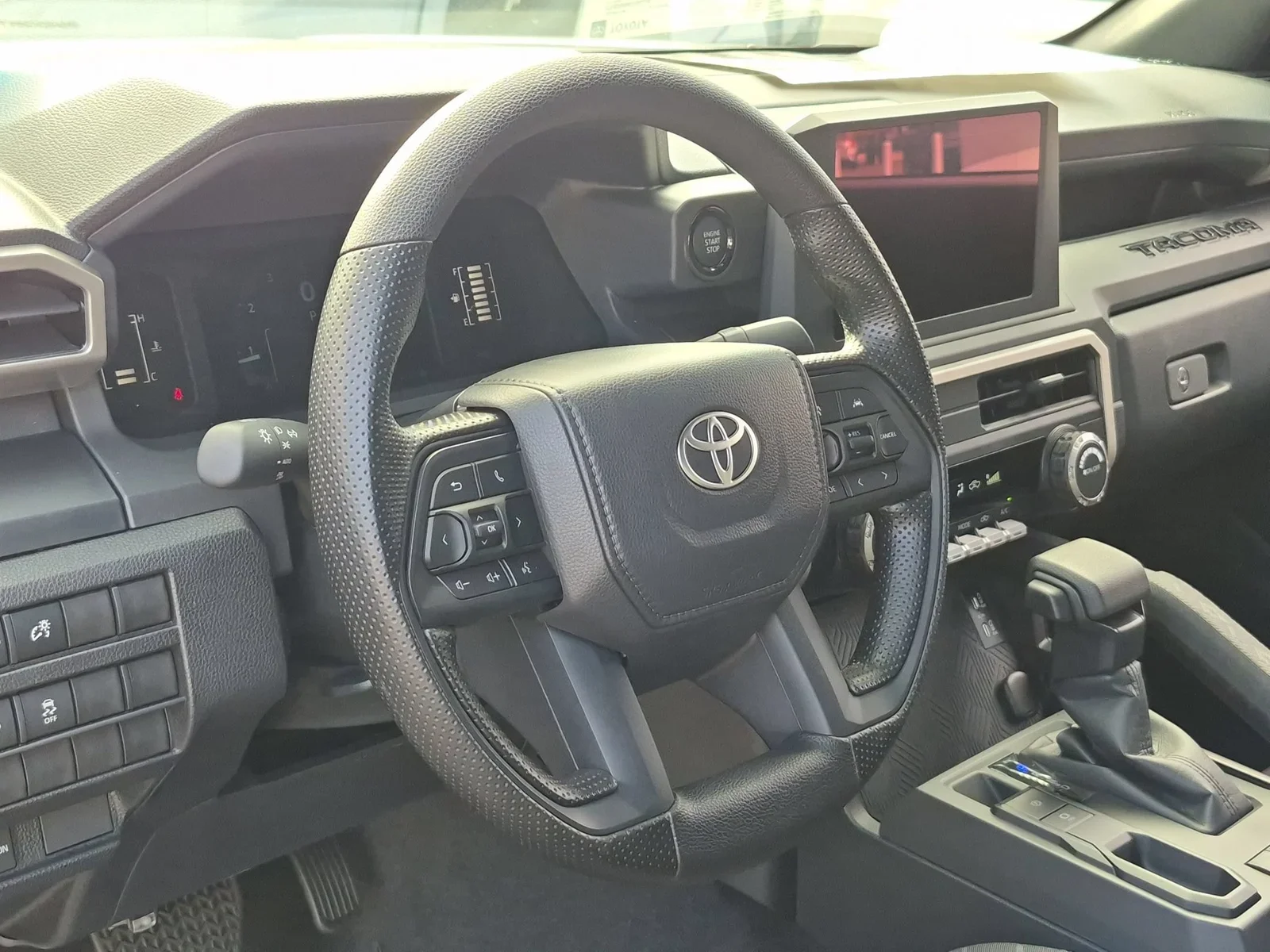 The dashboard and steering wheel of a 2026 Toyota Tacoma with the digital instrument cluster