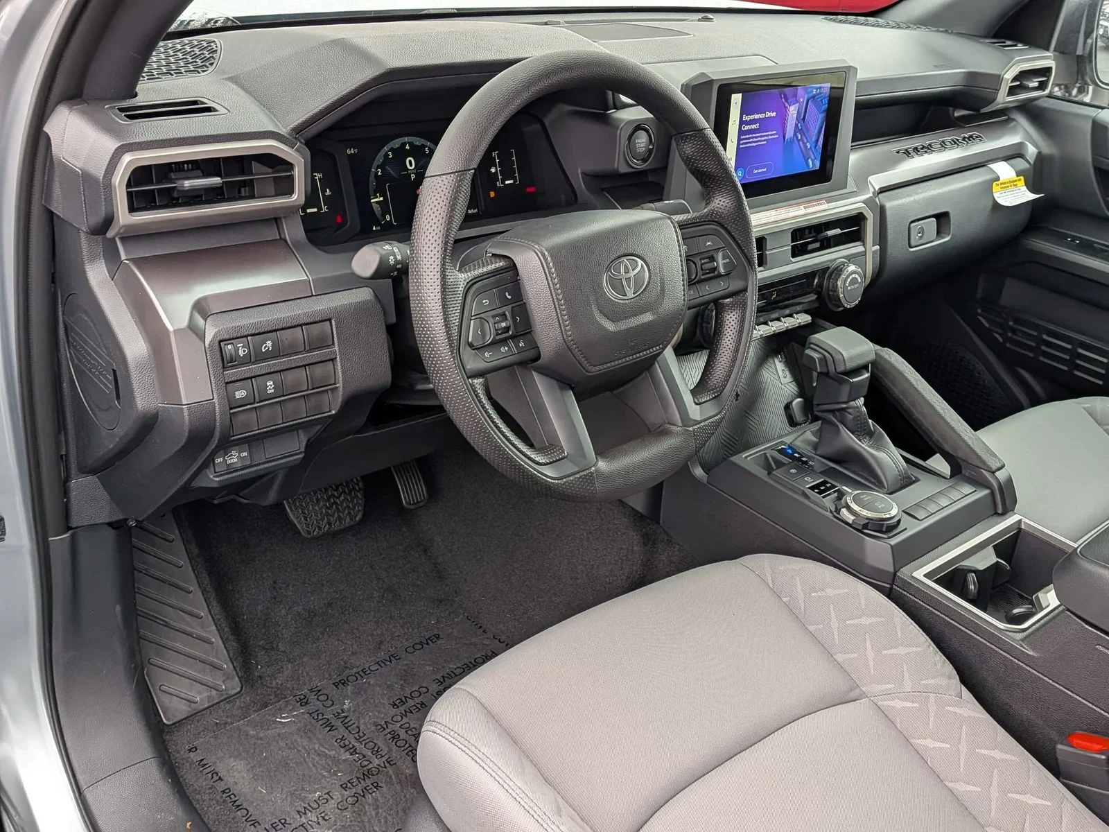 Interior of a Toyota Tacoma showing the dashboard, steering wheel and touchscreen